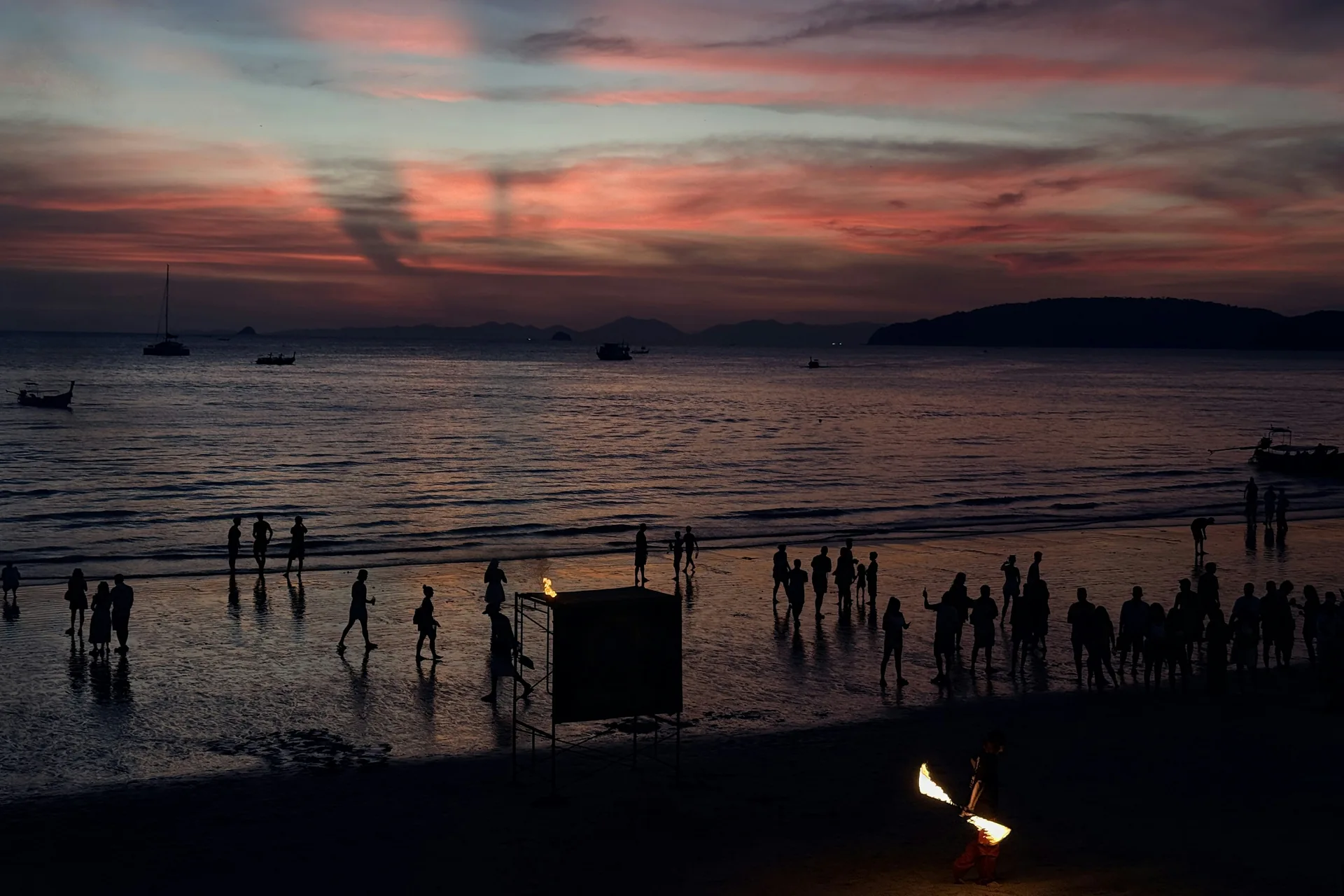 A Polynesian performer silhouetted against a sunset on a Hawaiian beach