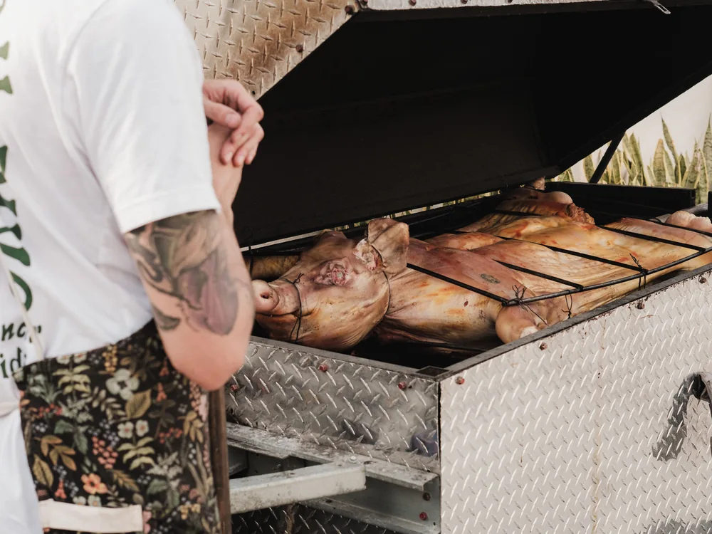 A whole pig roasting over an open fire, prepared for a Polynesian-style feast